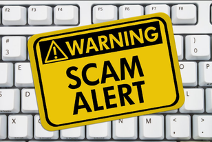 Scam Alert Sign on Top of Keyboard