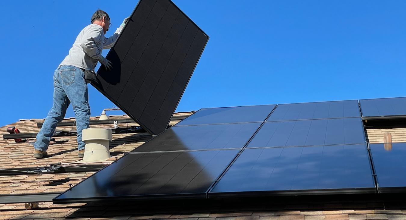 Man Installing Solar Panels on Roof